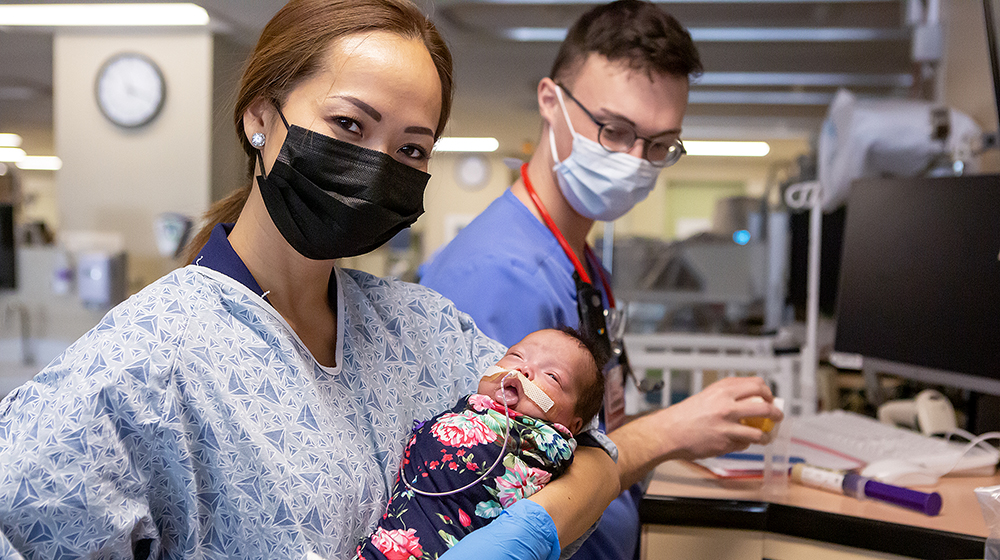 Assistant Professor Thao Griffith holds a newborn